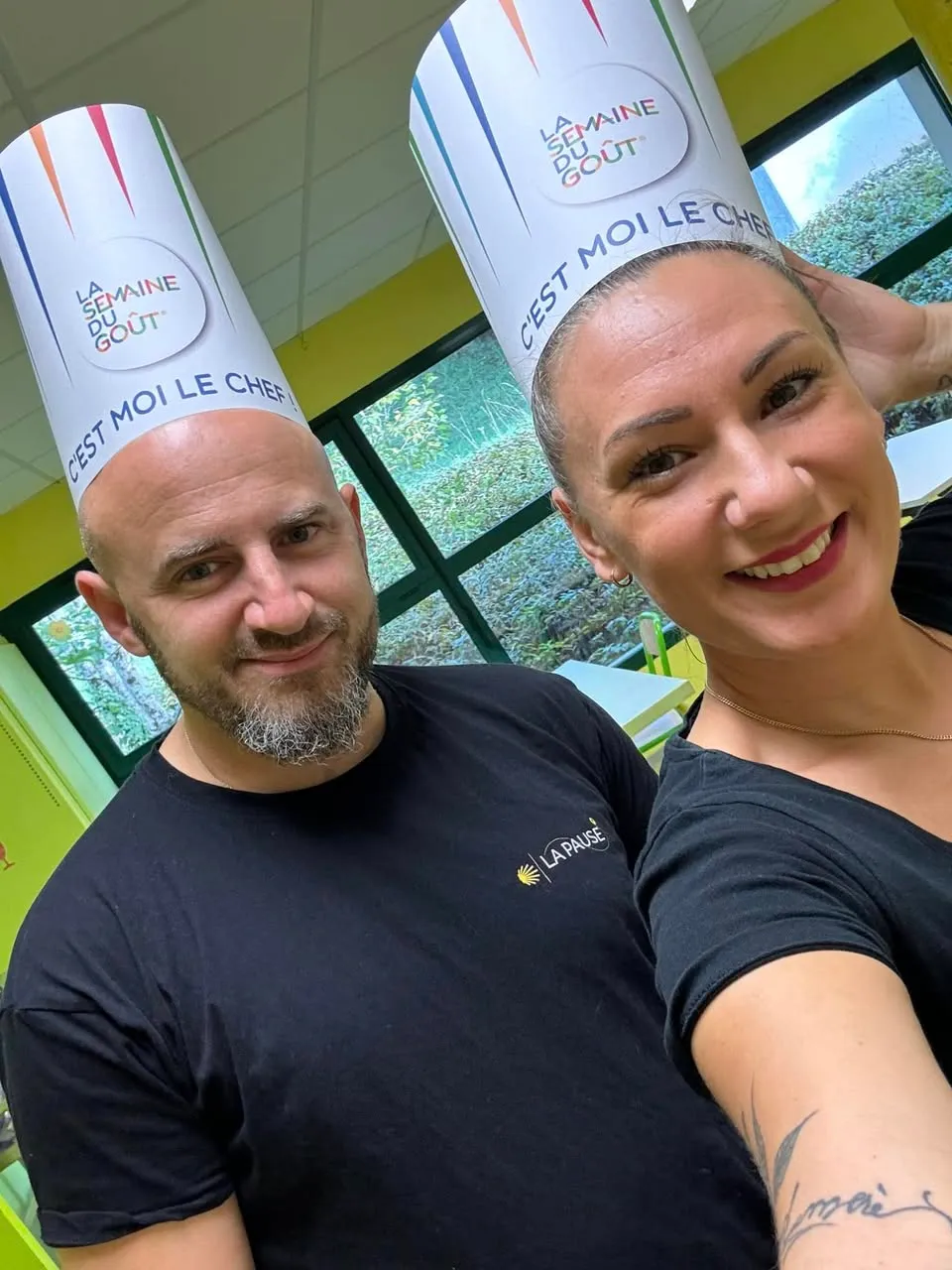 Valérie et Damien, souriants, coiffés de toques en papier